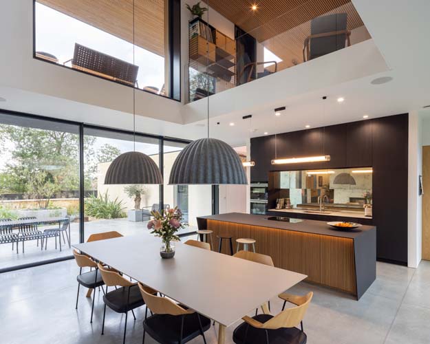 Contemporary kitchen with large floor-to-ceiling windows allowing natural light