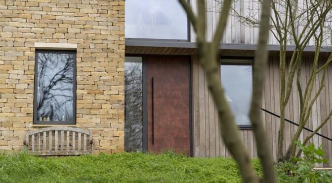 Industrial style aluminium front door with Corten finish and glazing
