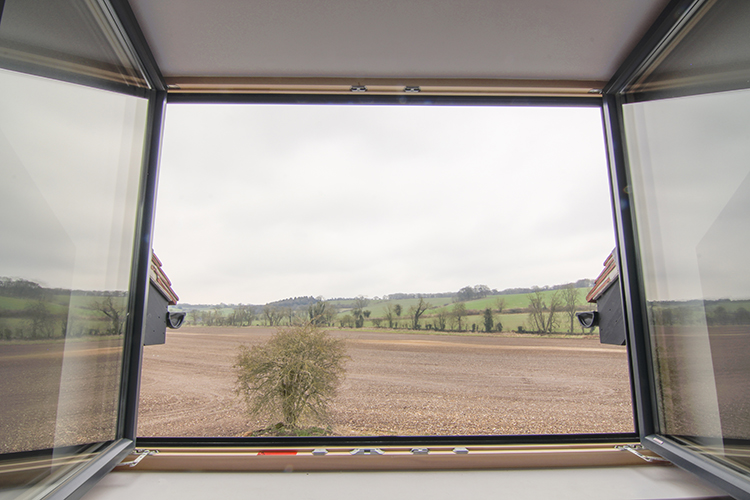 French windows opening onto a balcony with uninterrupted countryside views