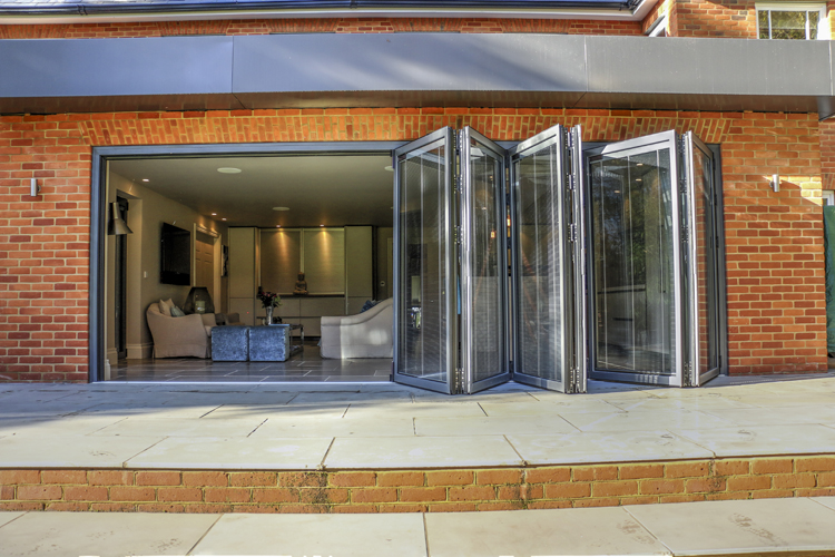 Contemporary aluminium bifold doors opening onto a modern garden patio