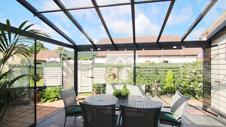 Luxury glass atrium design connecting a home extension to the garden