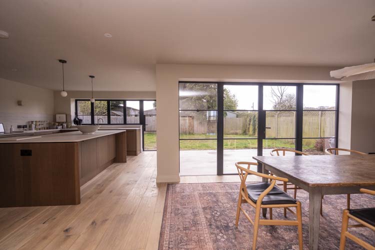 Open-plan kitchen with black aluminium bifold doors